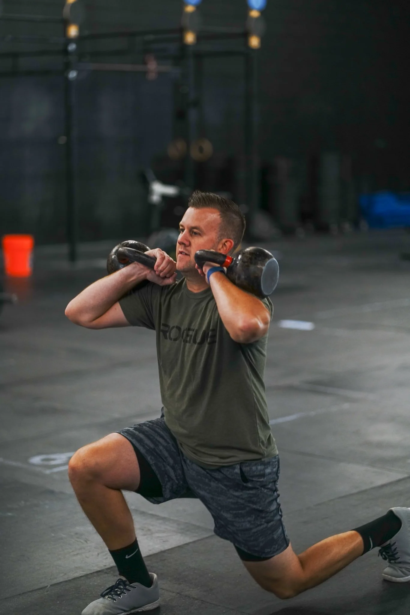 CrossFit physical therapy client performing a double front rack kettlebell walking lunge in South Portland, Maine.