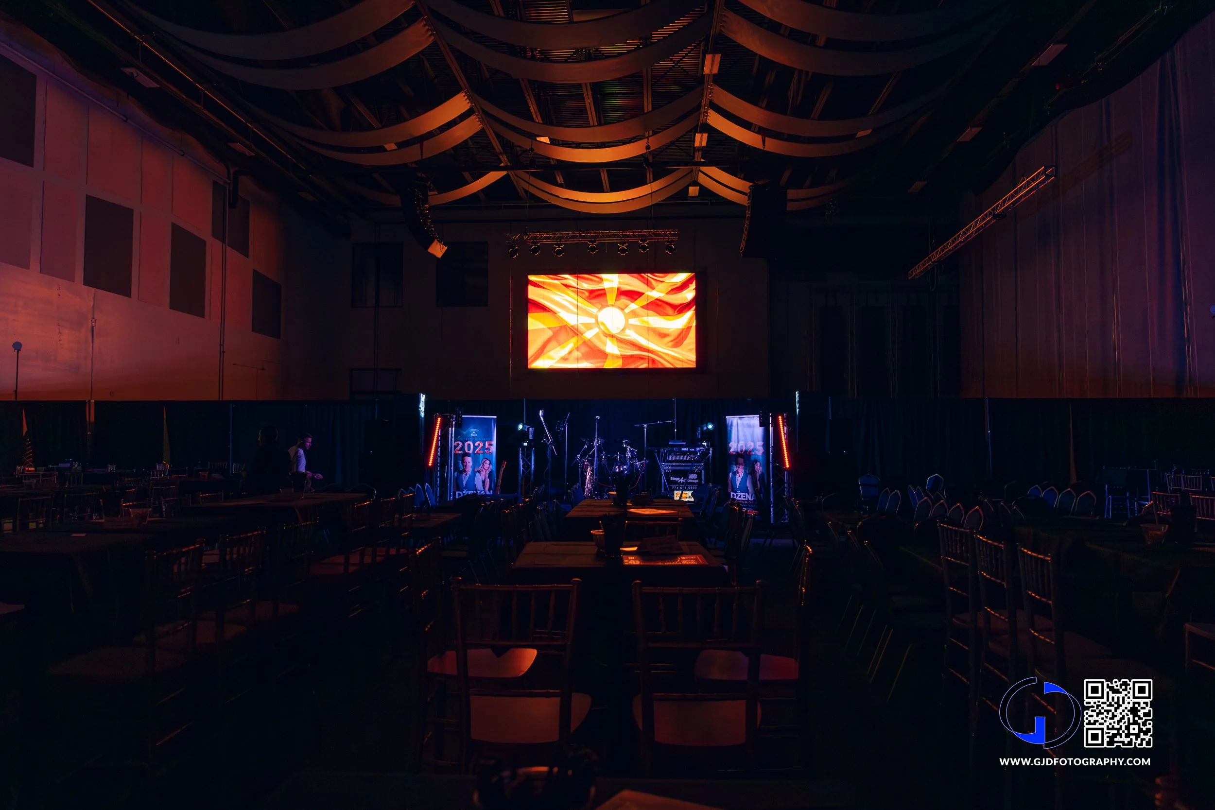 Empty event or concert hall with a stage, musical instruments, and lighting, awaiting a performance.