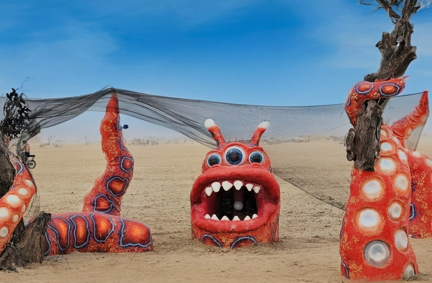 Beware the monster in the desert!👽
Good thing Carrie and Chris Jurney have it contained… seemingly. This imaginative piece is called Black Rock Monster Containment and it depicts a tentacled creature tearing apart a tree sculpture, while als