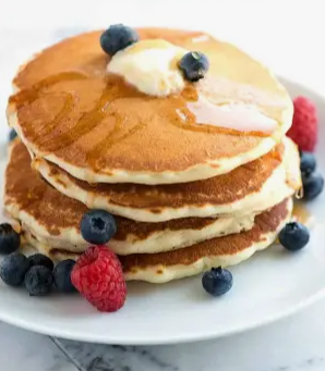 stack of pancakes with berries and syrup