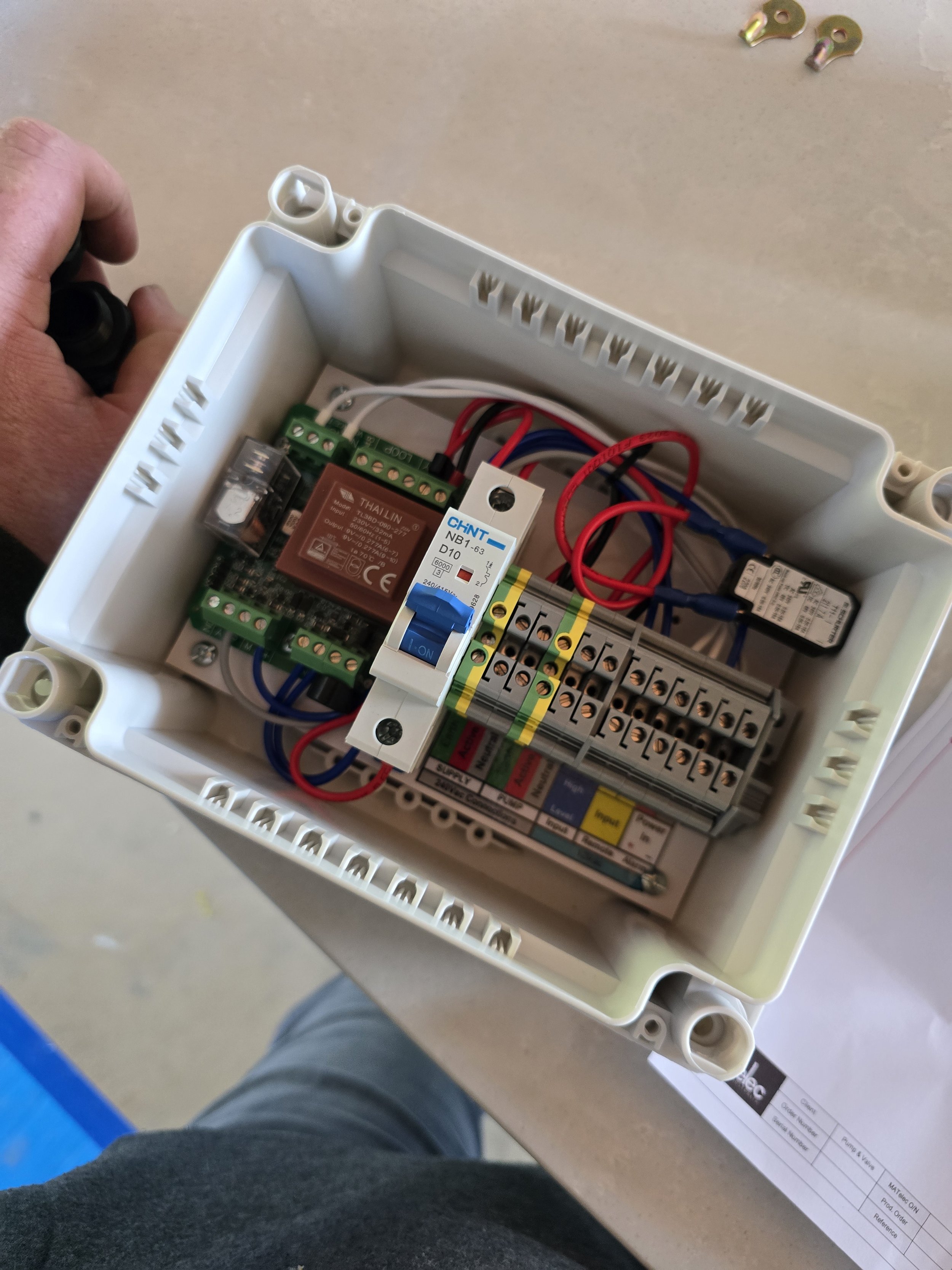 Electrical junction box with wiring, circuit breakers, and terminal blocks.