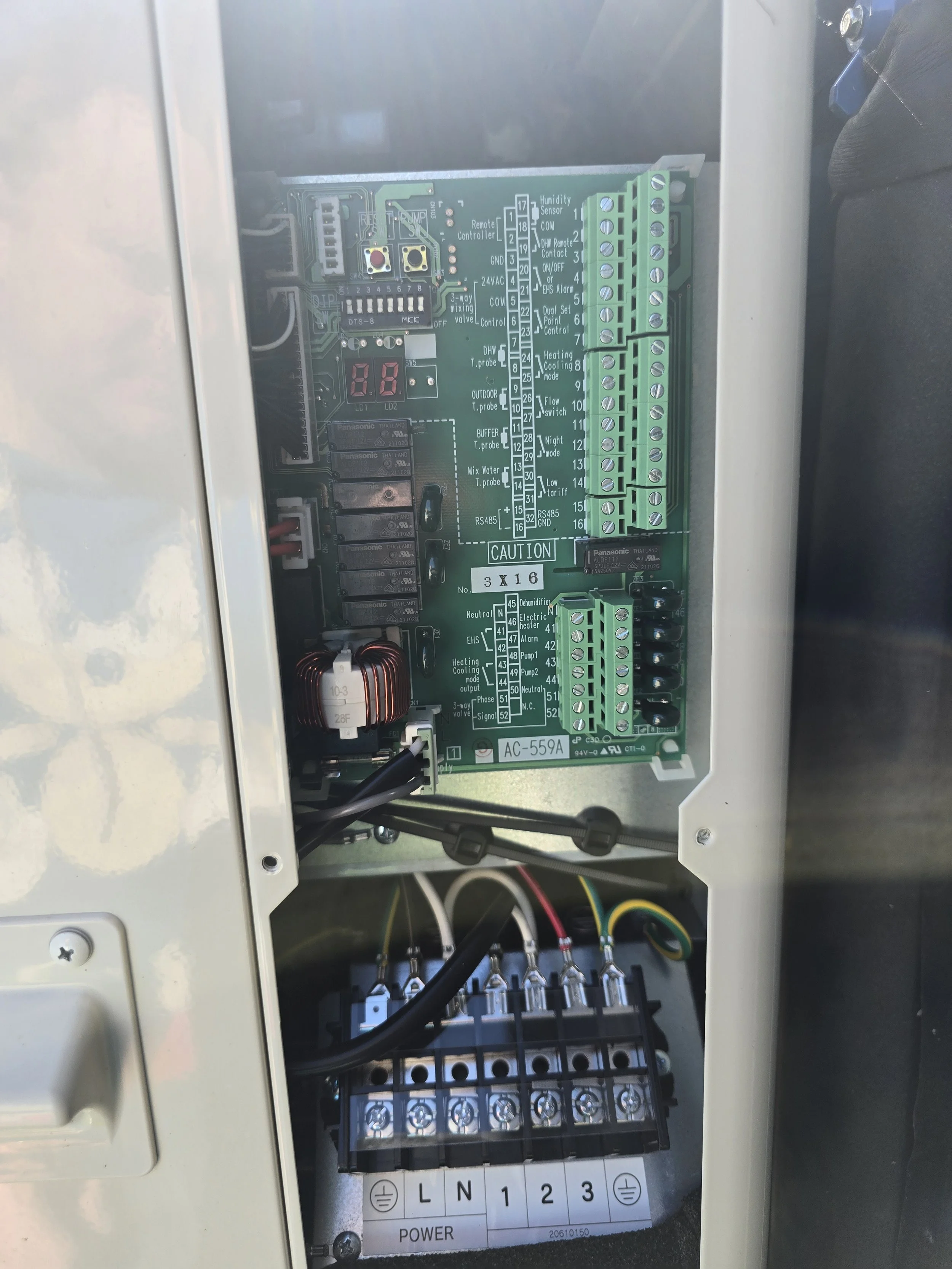 An open electrical control panel with circuit board and wiring.