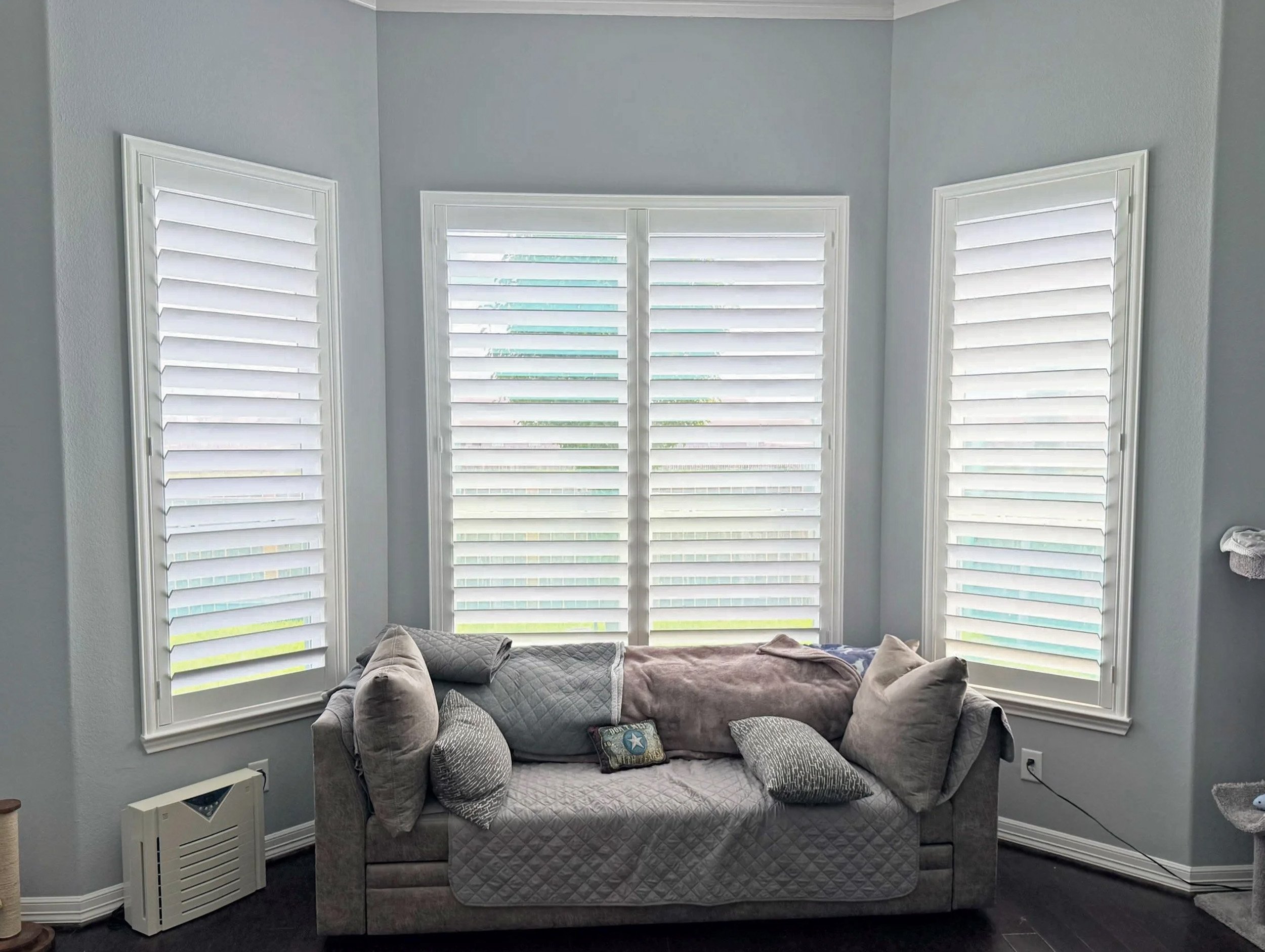 White plantation shutters across three windows with 4.5-inch louvers, hidden rear tilt, and a Traditional frame in a Houston bedroom.