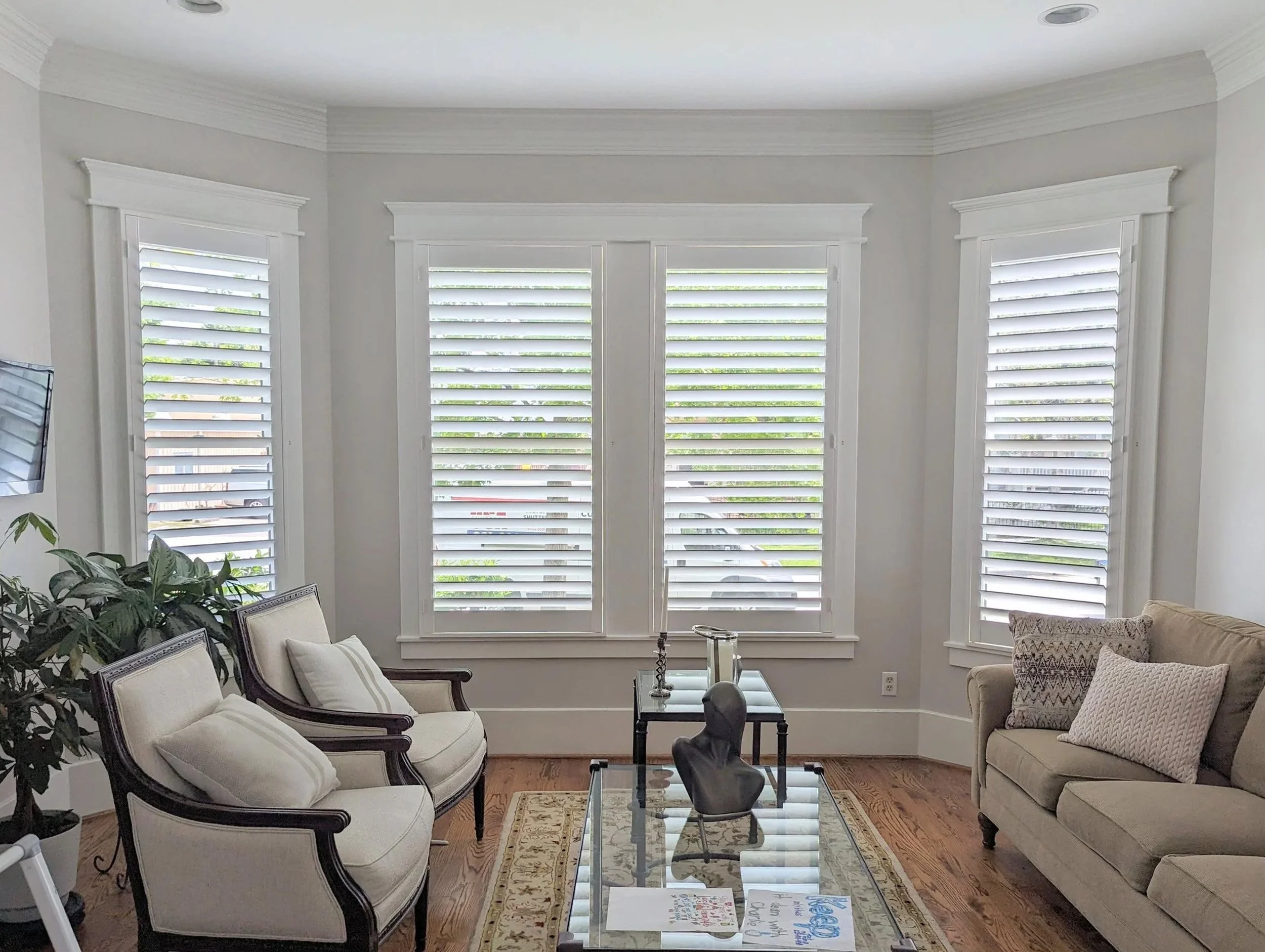Plantation shutters across three windows with 3.5-inch louvers, hidden rear tilt, and a Traditional frame in a living room.