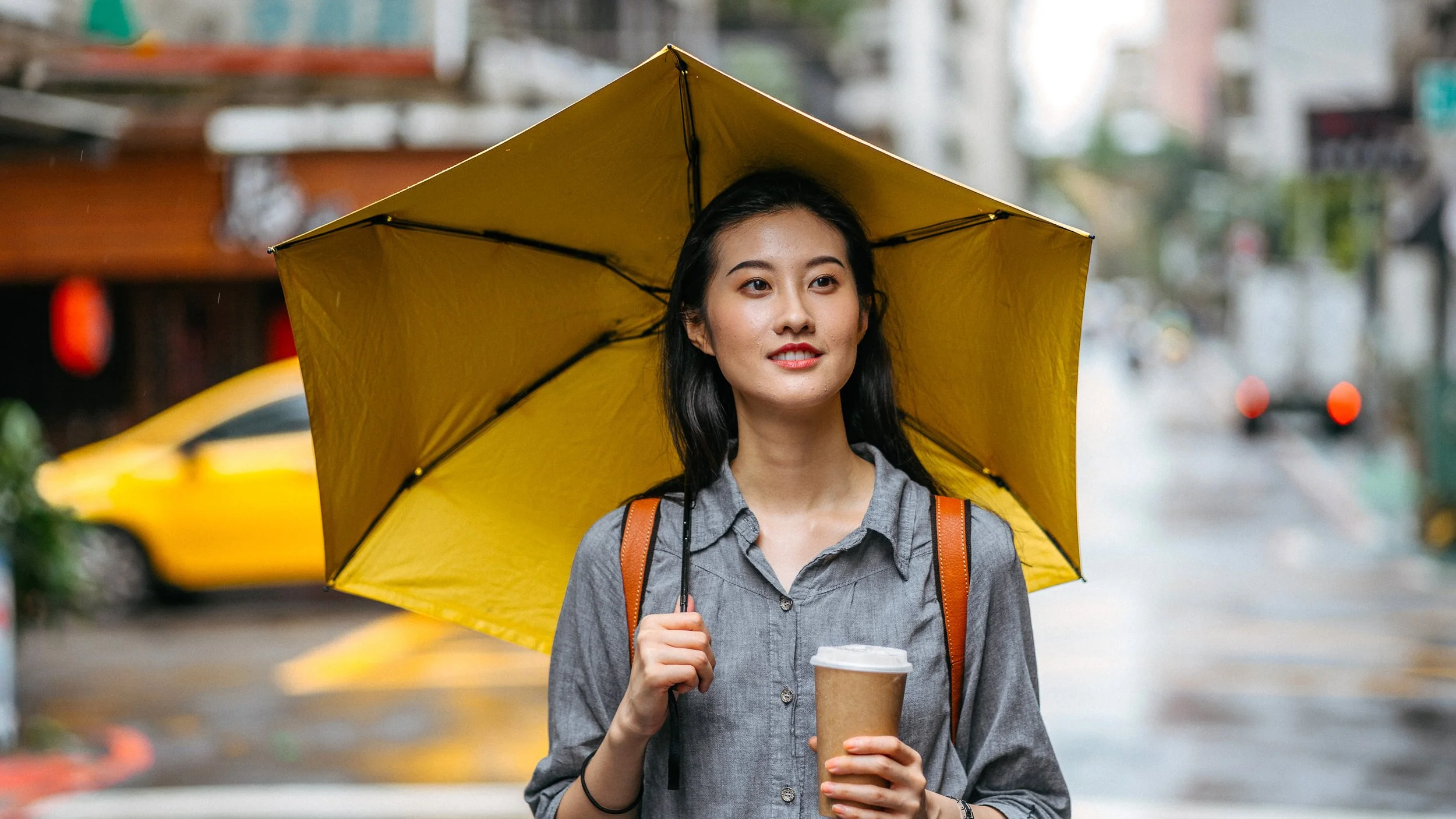 Woman holding an umbrella, symbolizing protection and confidence, accompanying an article about self‑advocacy at work.