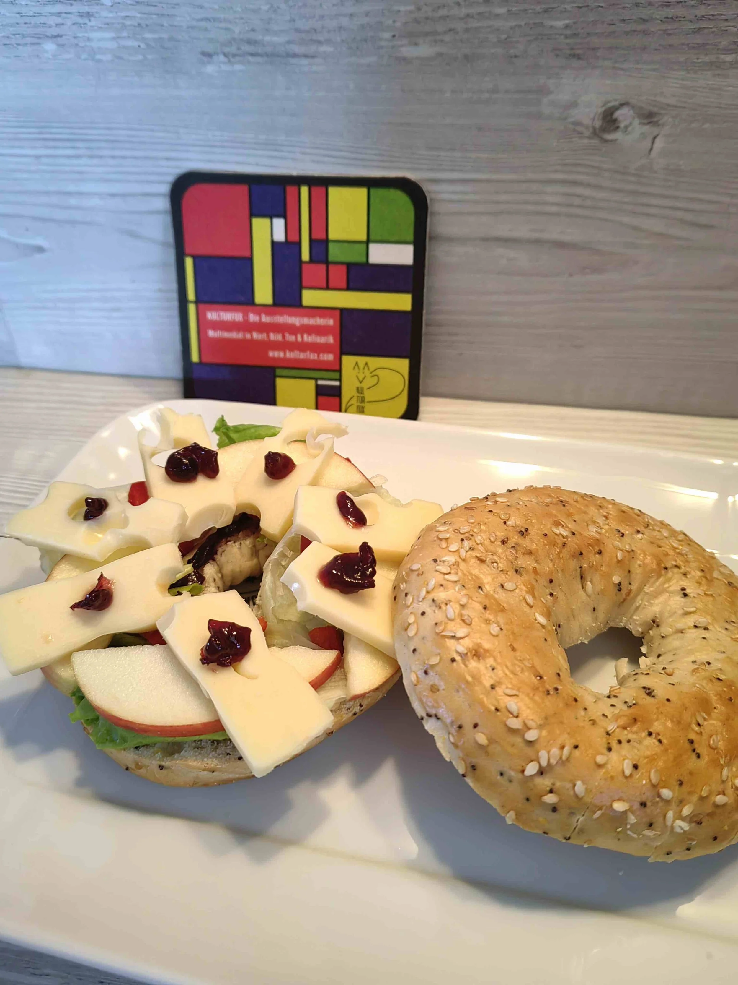 CHEESE-BAGEL mit Preiselbeeren, Salat und Apfel