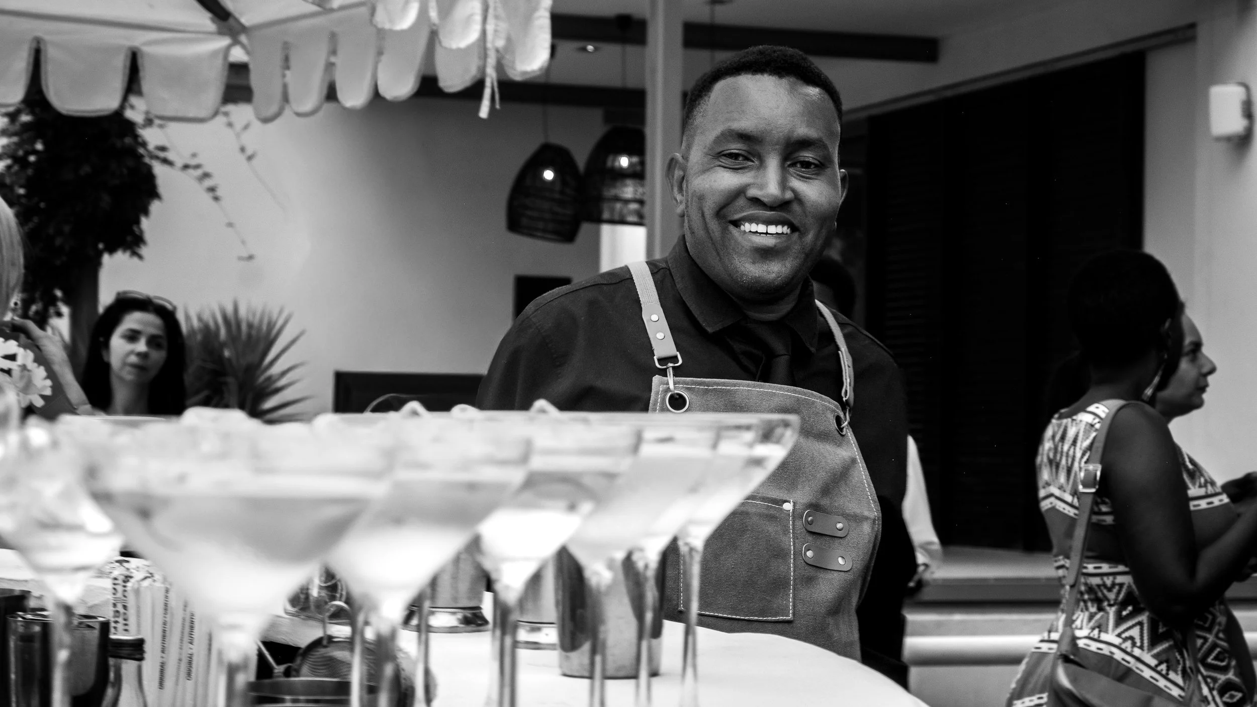 smiling bartender with beautiful cocktails on the bar.
