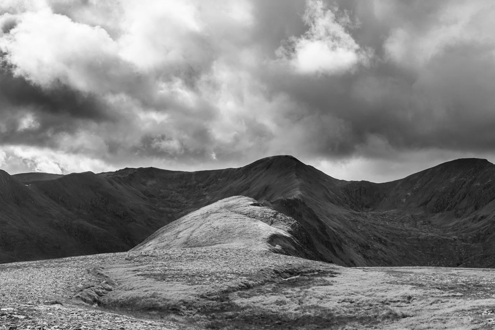 Sgurr na Lapaich, standing proud in the Scottish Highlands. Reaching this view took three hours of off-path climbing, through bursts of warm sun, sudden rain, and shifting clouds that rolled over the ridges. The light came and went in seconds, painti