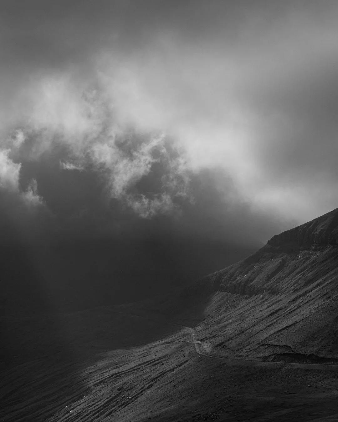In the Faroe Islands, the clouds dance across the sky, never in the same place for more than a heartbeat. The light follows, spilling over the land in fleeting moments, brushing the hillsides with soft, golden strokes before retreating into shadow. S