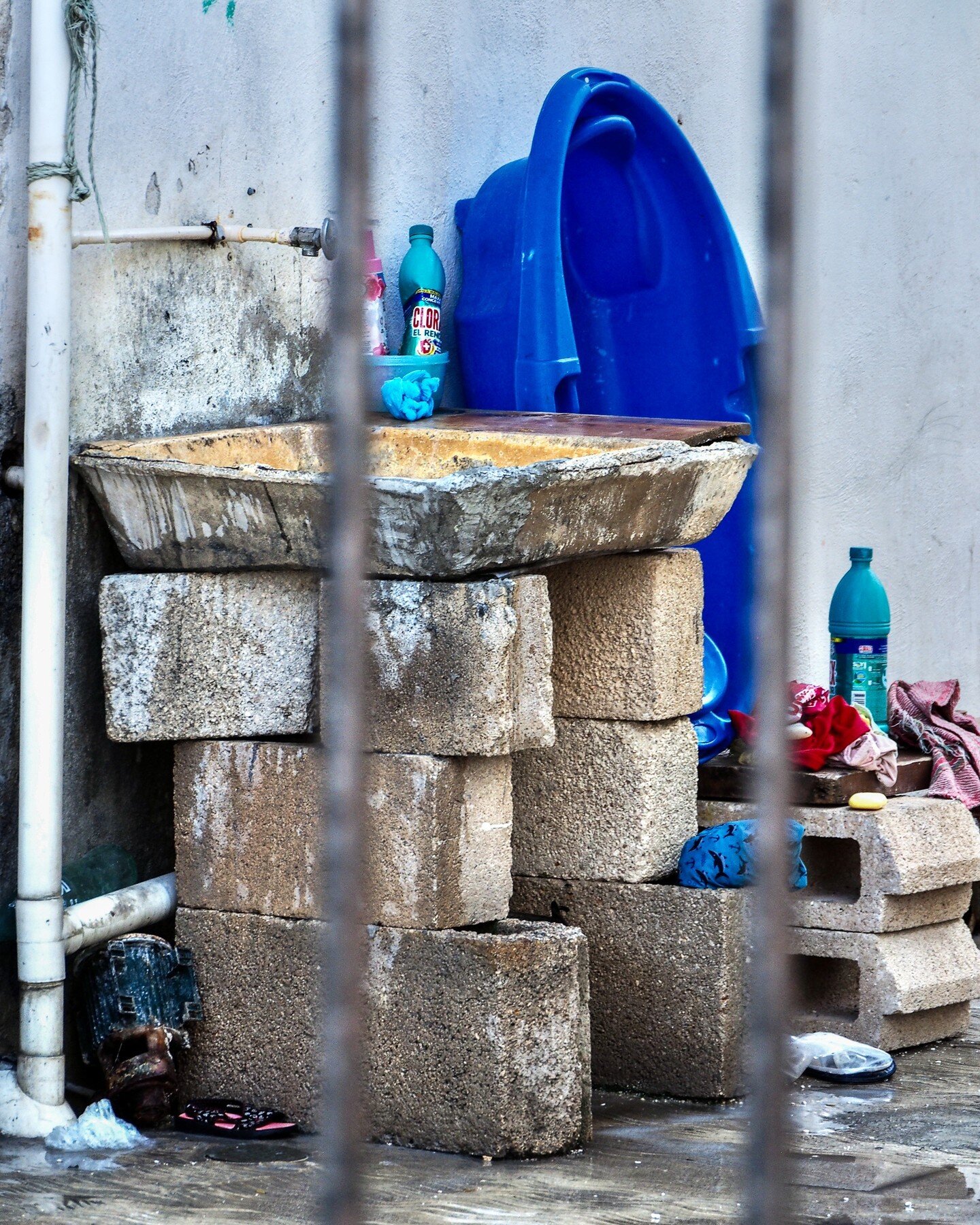 𝗧𝗛𝗘 𝗦𝗧𝗢𝗥𝗬 𝗢𝗙 ...
𝗪𝗵𝗶𝗹𝗲 𝗜 𝘄𝗮𝘀 𝗶𝗻 ... 🇲🇽
🍥 Playa del Carmen. A Greco-Roman style sink suddenly and unexpectedly appears behind the steel bars of the side entry gate.
The deep blue colour adds dimension to the whole scene. 
*
🇲?
