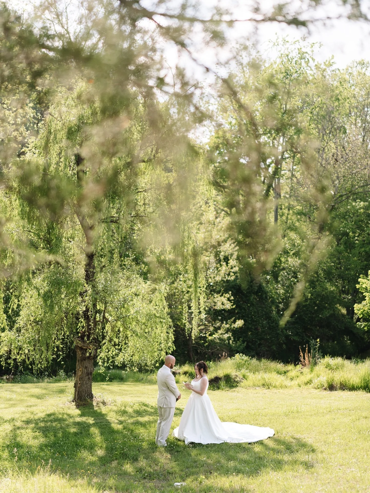There&rsquo;s something so magical about finding a quiet moment in the middle of a wedding day.
Under the sweeping branches of the willow tree at our venue, these two paused to read the words they had written straight from their hearts. Just the two 