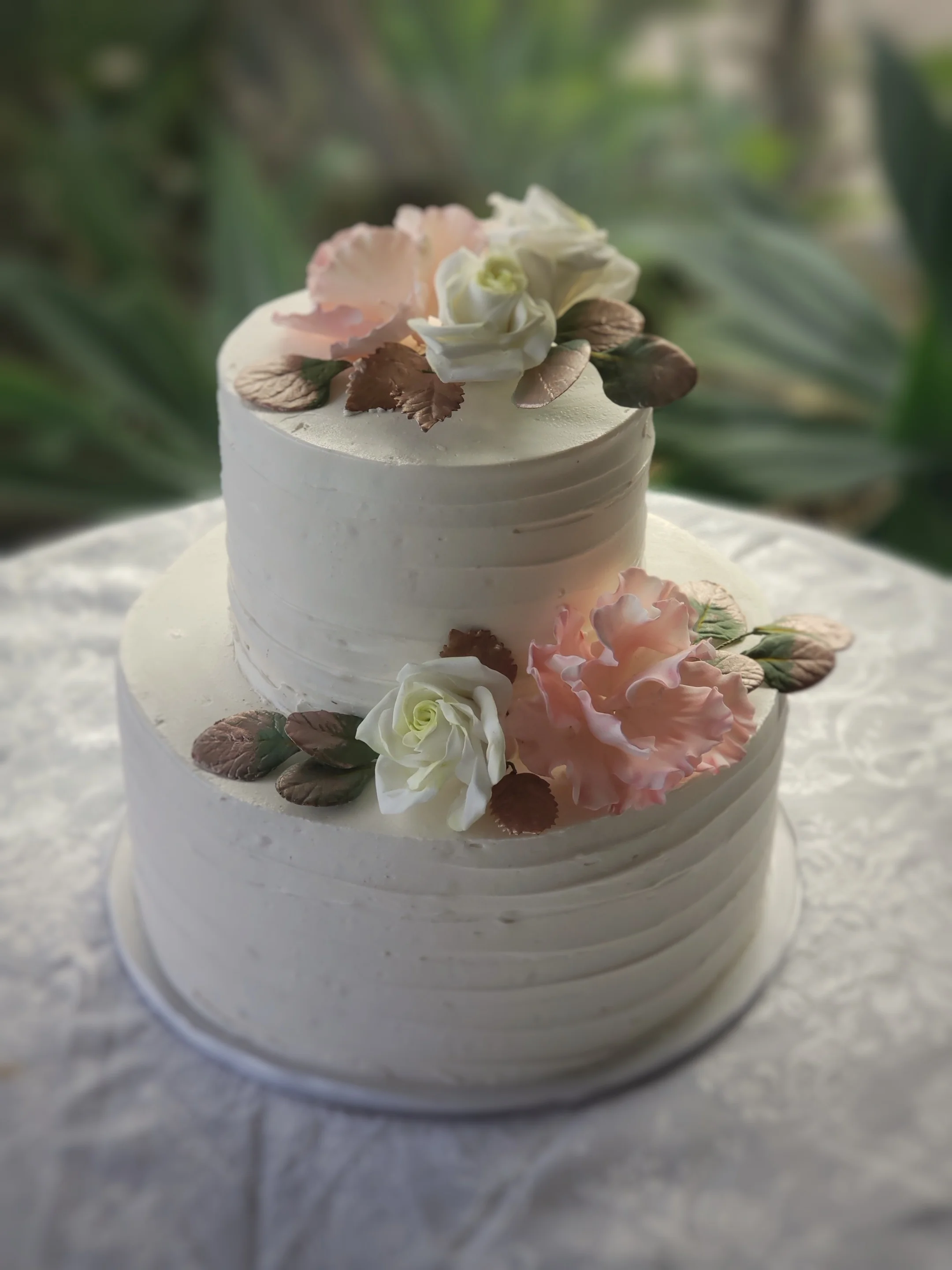 Two tier round textured buttercream wedding cakewith sugar peonies, roses and rose gold leaves Hilo Hawaii Big Island Kailua-Kona