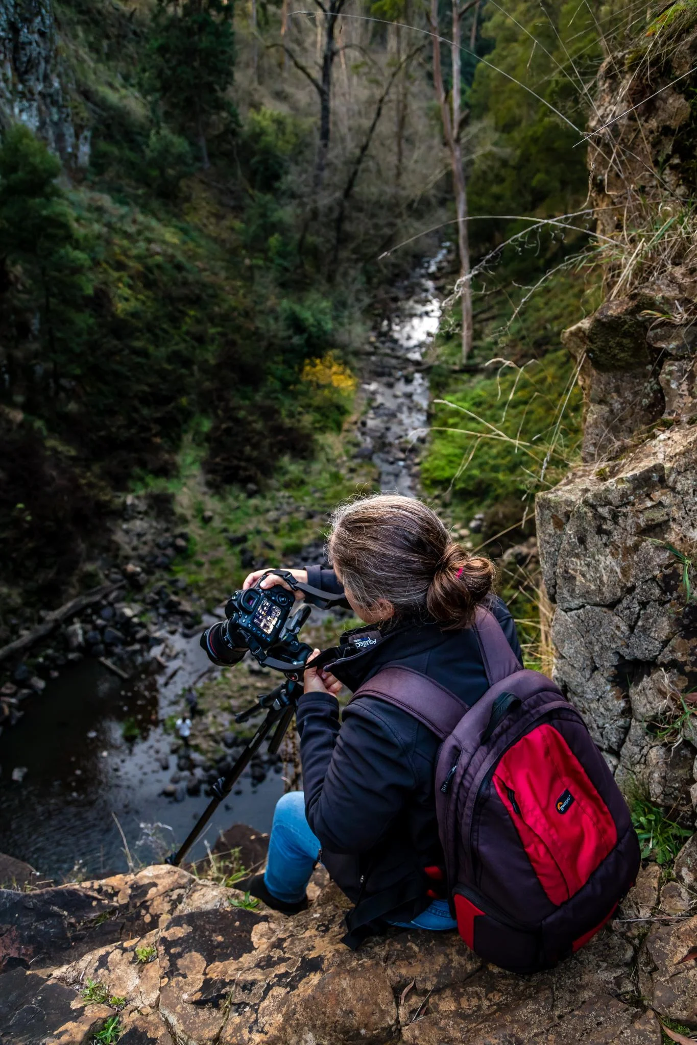A photographer sits on the edge of the falls. the falls are a 32 metre drop to the river bed below. Russell Charters Images. This work is licensed under Creative Commons. https://www.flickr.com/photos/russellcharters/27560443307
