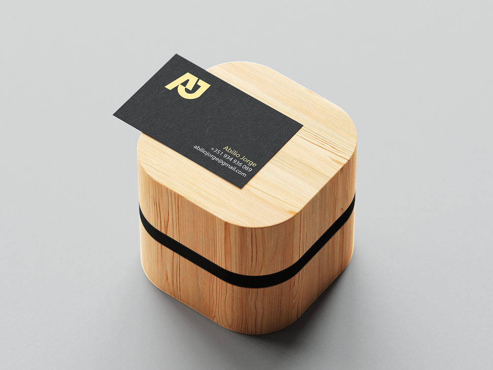 Black business card with the monogram on a wooden block.
