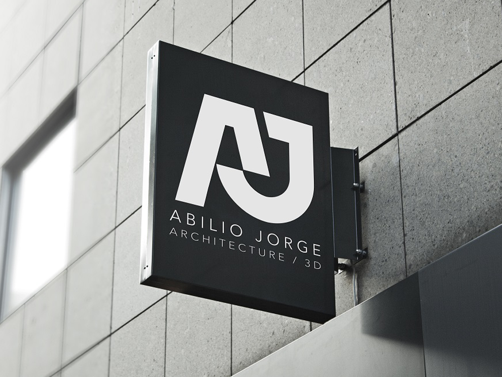 Square hanging sign with the AJ monogram on a building facade.