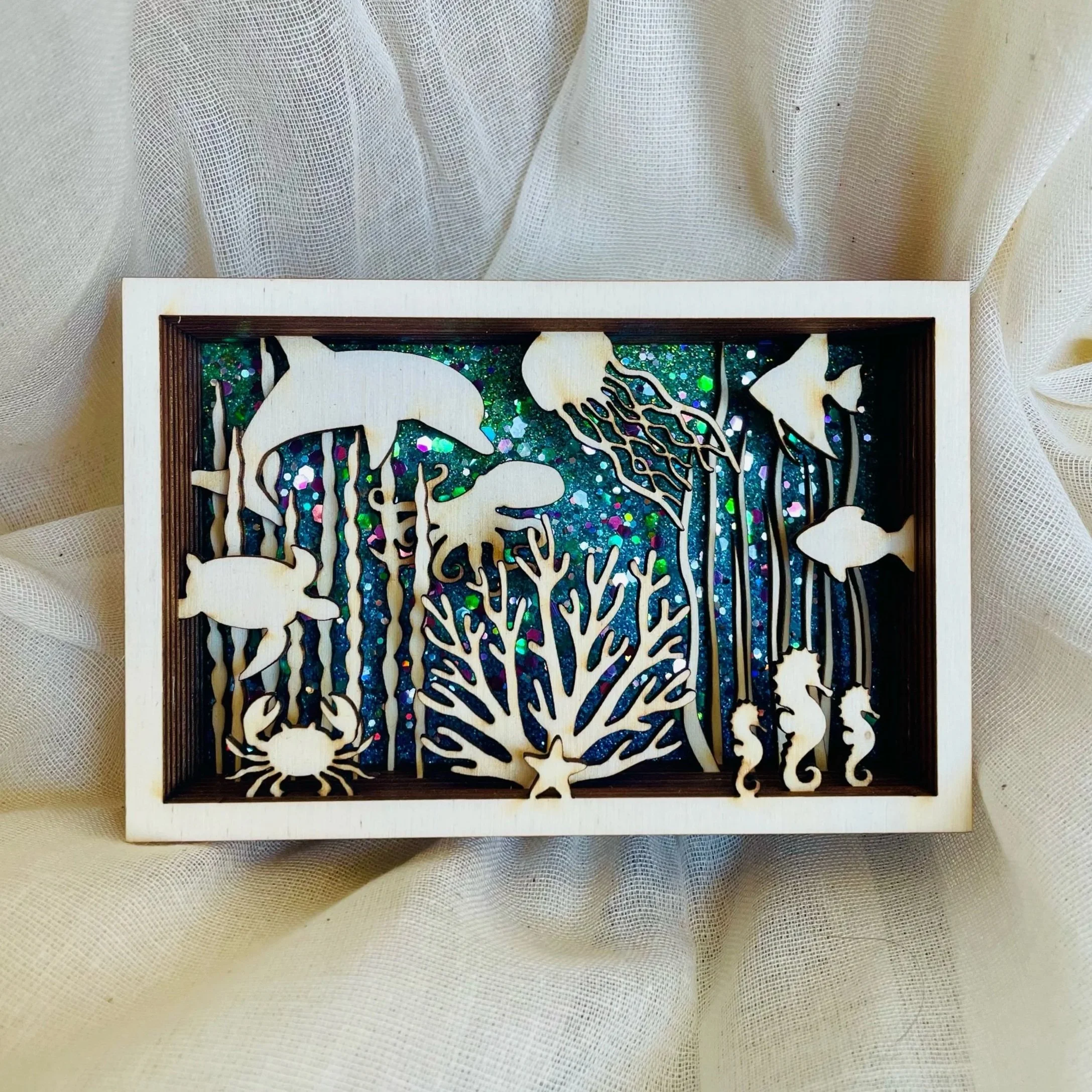 layers of laser cut wood creating a 3D scenery of underwater animals
