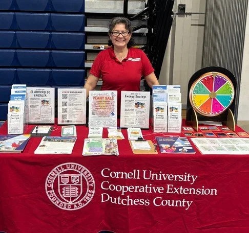 Woman behind table with information located in a gymnasium
