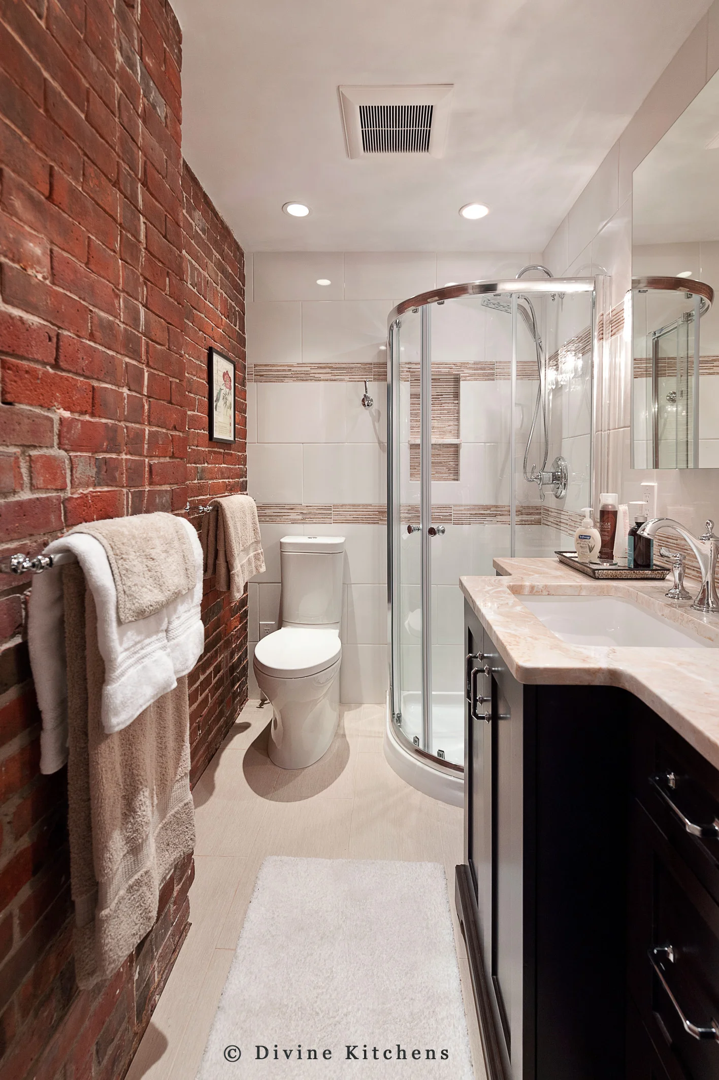exposed brick, marble countertops, glass partition, tile backsplash. Two piece toilet. Darkwood vanity.