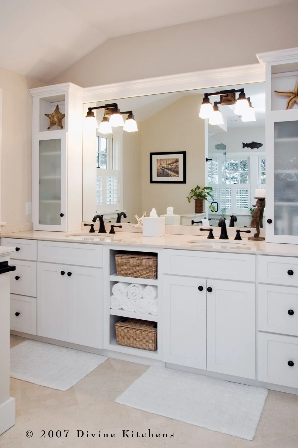Beach inspired master bathroom with bronze oiled accessories, white shaker cabinets, pothos greenery, and starfish decor
