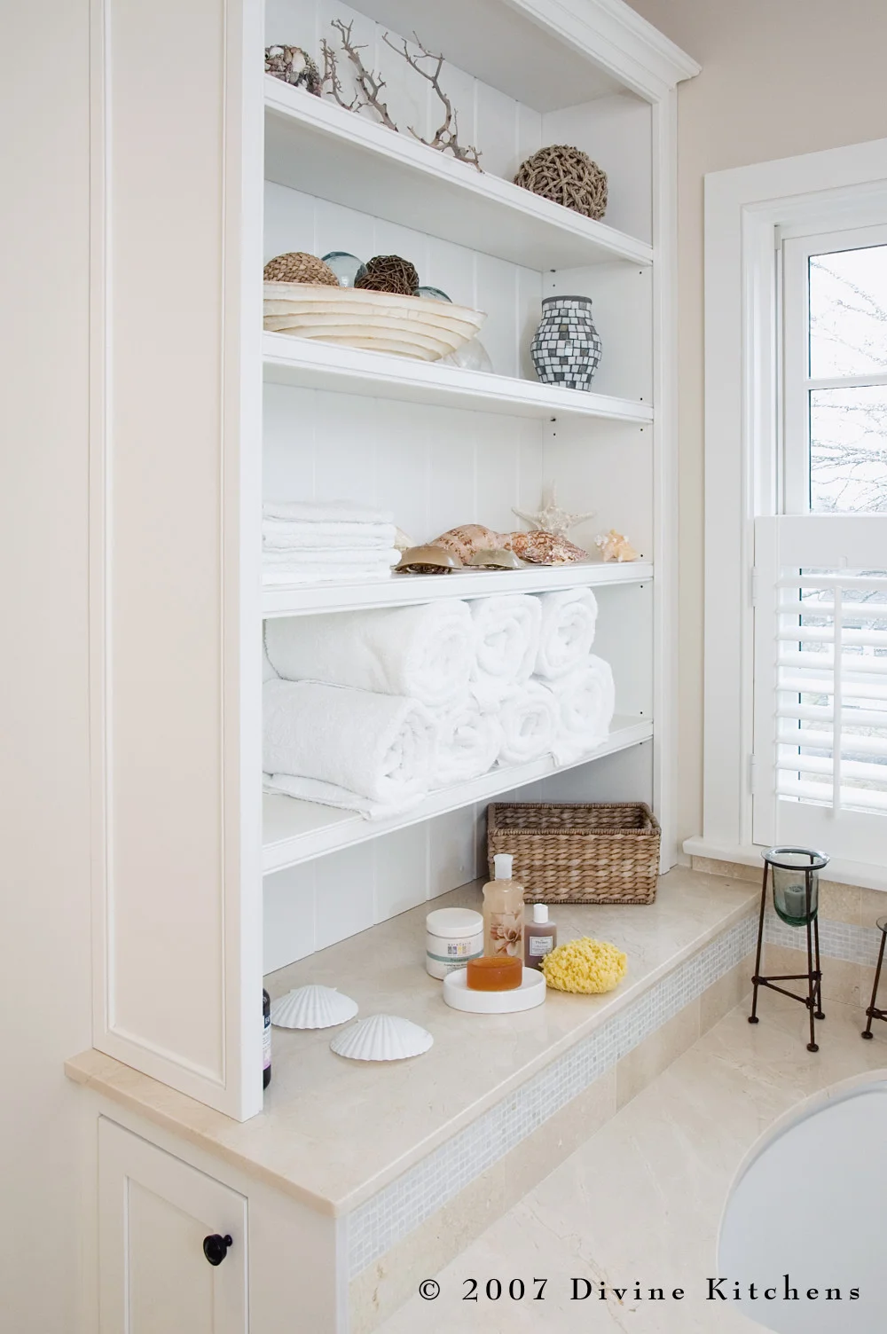 Beach inspired master bathroom with bronze oiled accessories, white shaker cabinets, pothos greenery, and starfish decor