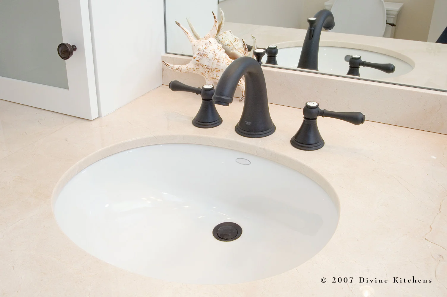 Beach inspired master bathroom with bronze oiled accessories, white shaker cabinets, pothos greenery, and starfish decor
