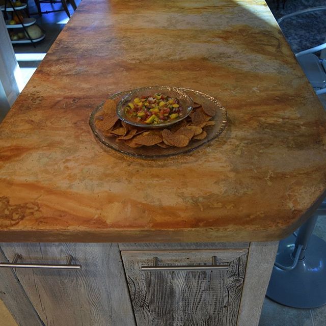 Only an artist can take a plain white slab of a concrete counter top and turn it into this rustic looking work of art by throwing the rust tones of acid onto the surface!! The base of this kitchen island was created out of barn wood from artist Larry