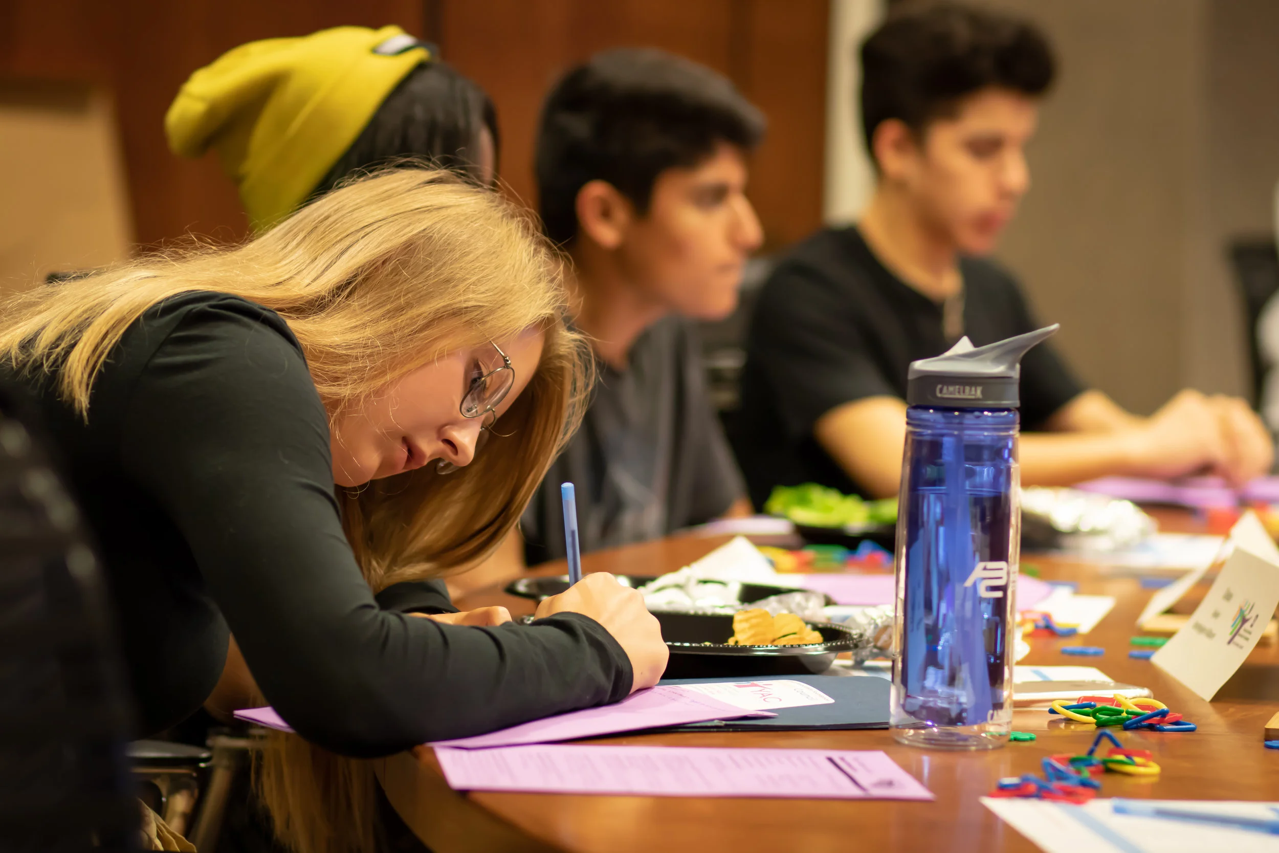 Grace Wilcox (left) takes notes as Dreams on Horseback representatives present their proposal for grant funding.