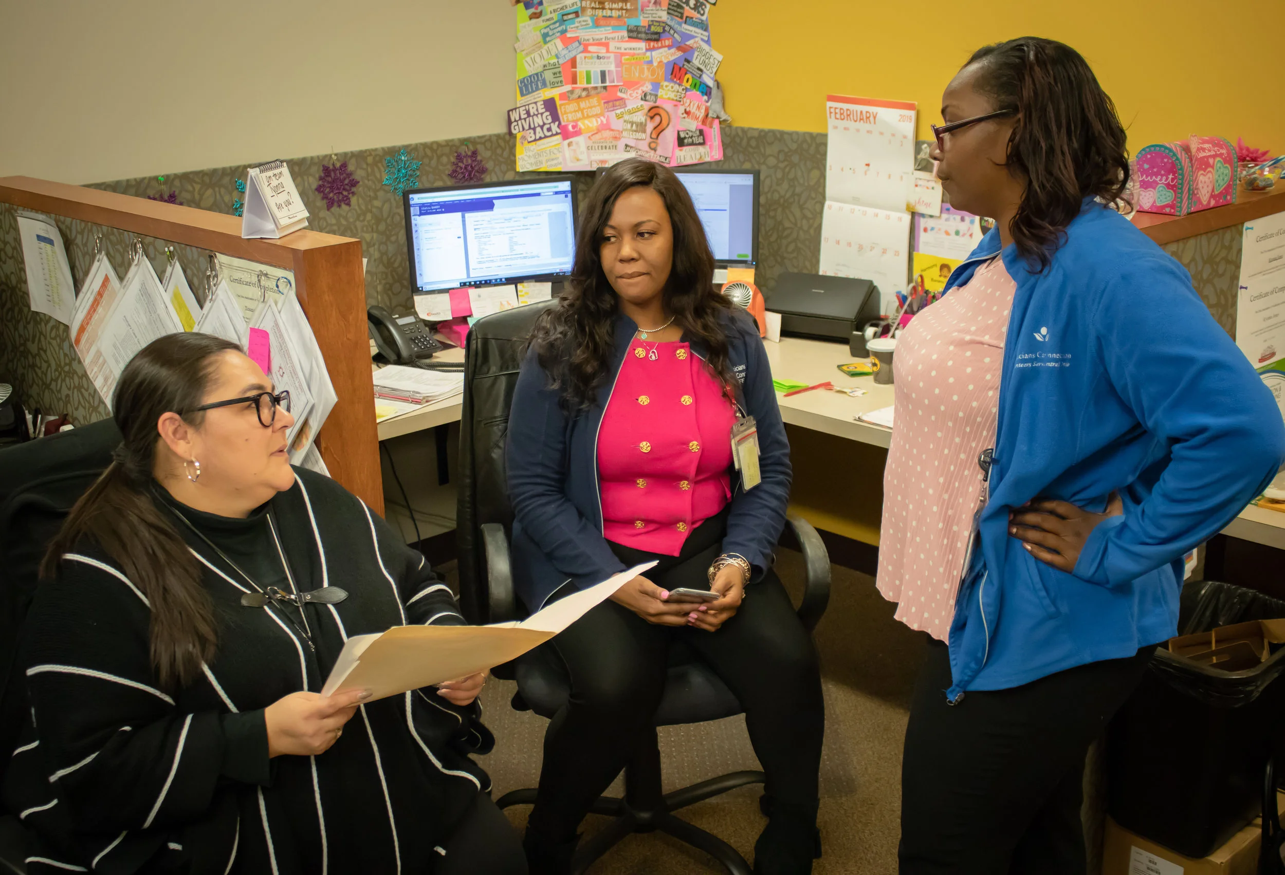 Yesenia Rodriguez (left) discusses a patient’s case with her coworkers.