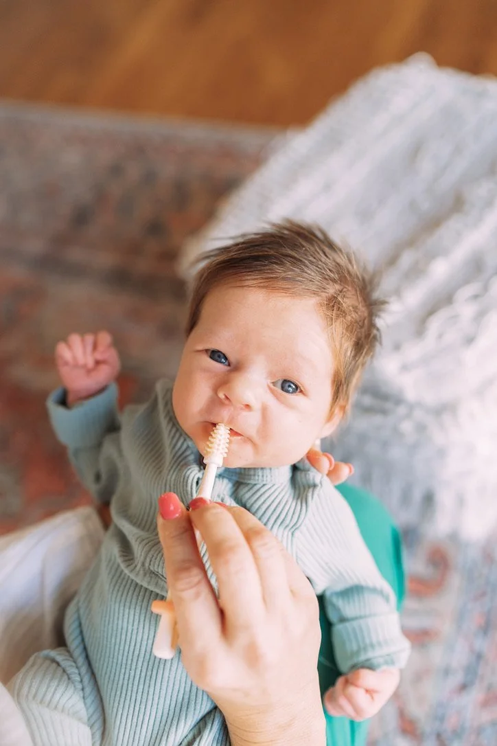 Photo of a baby working in therapy on using his mouth muscles.