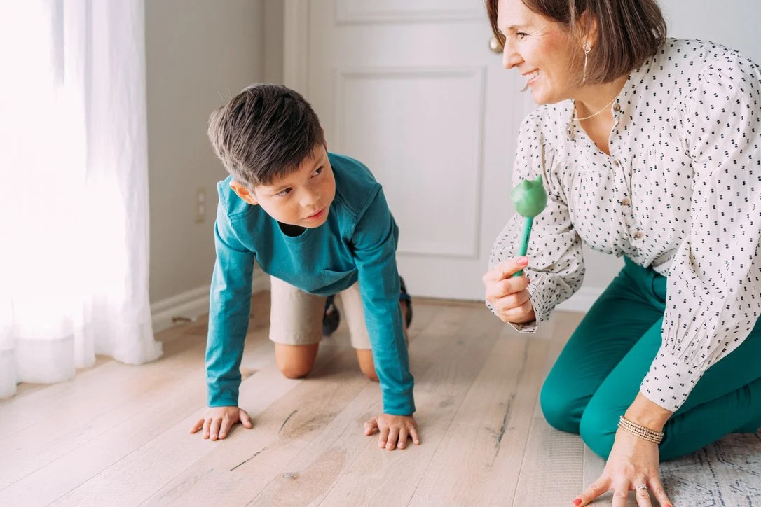 10 year old boy demonstrating a occupational therapy exercise on his hands and knees.