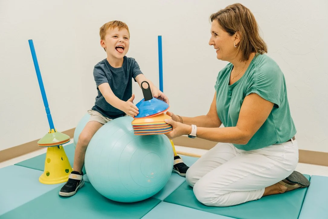 5 year old boy, sitting on bouncy ball in Occupational Therapy
