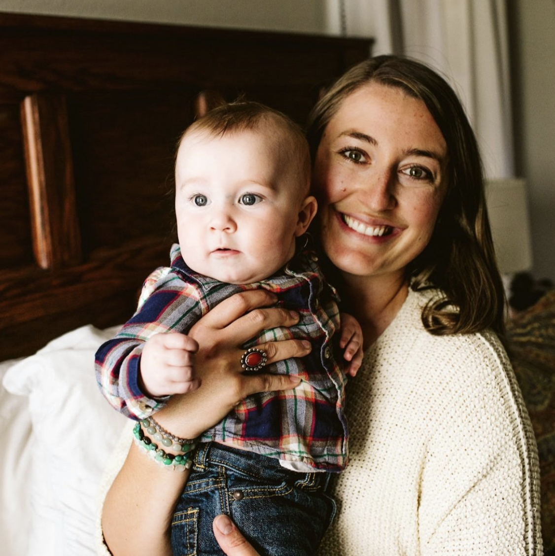 Katie Braswell, Preconception Group Coach, holding son and looking at the camera.