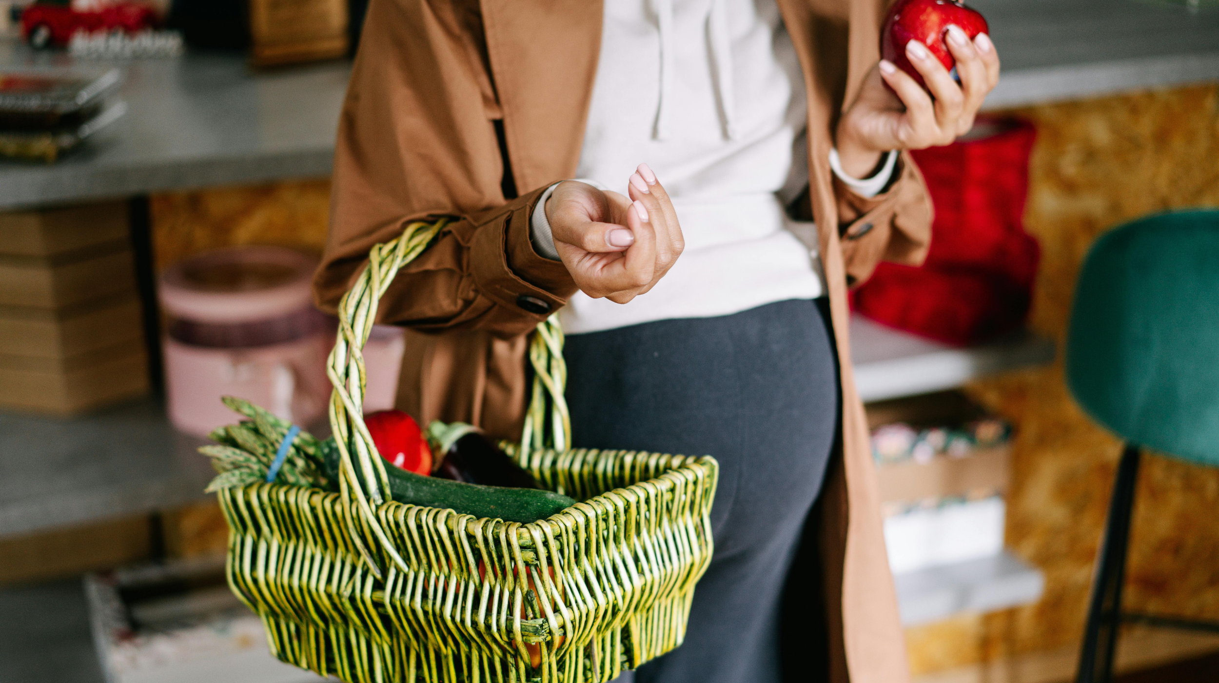 Pregnant woman holding fruits and vegetables.