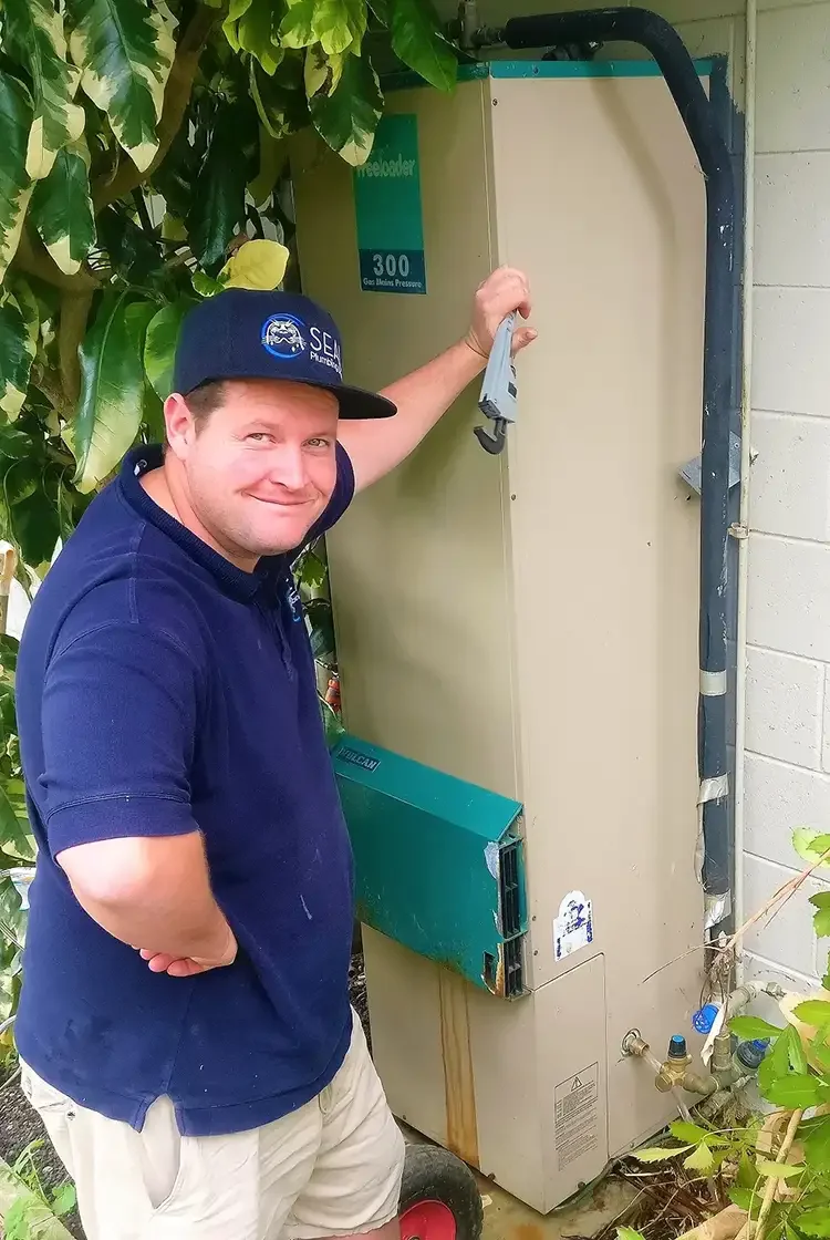 Seal Plumbing Steve infront of old hot water system
