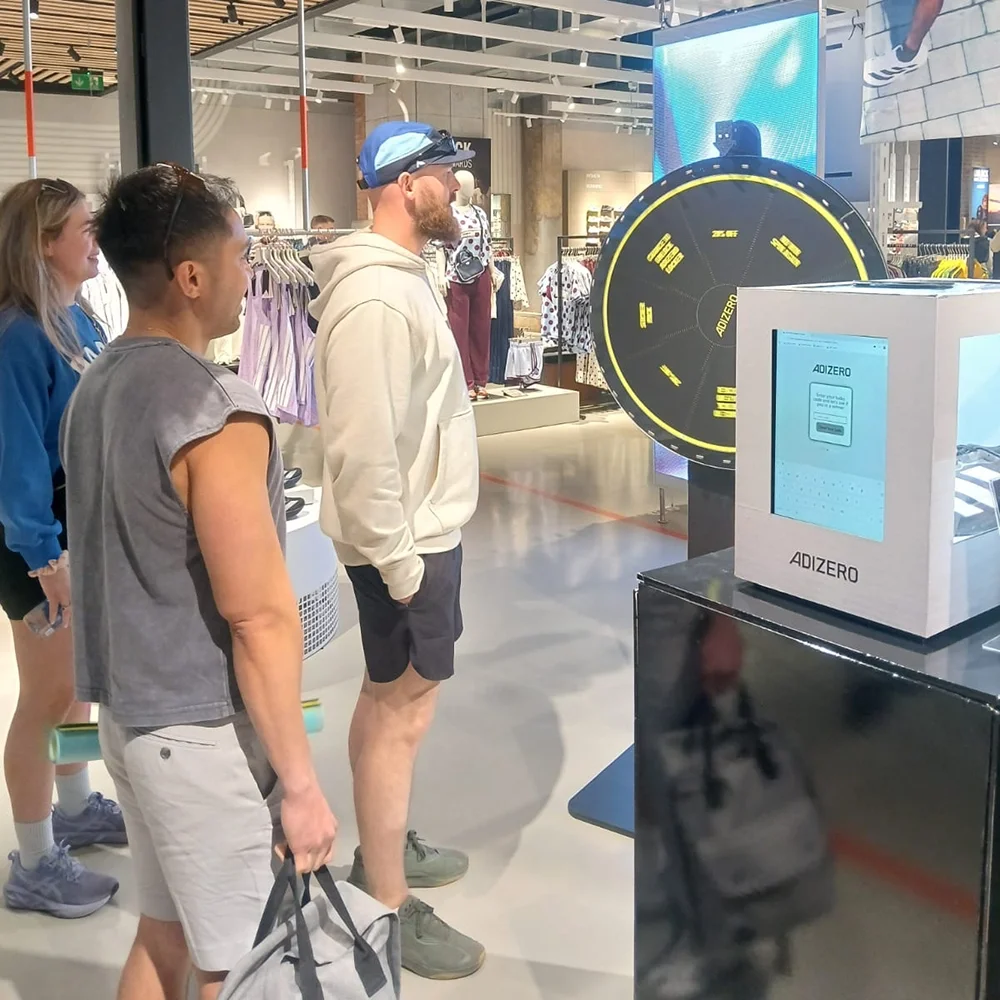 Shoppers gathered around the ADIZERO Lockbox activation and spin-to-win wheel at Adidas Battersea Power Station, London.
