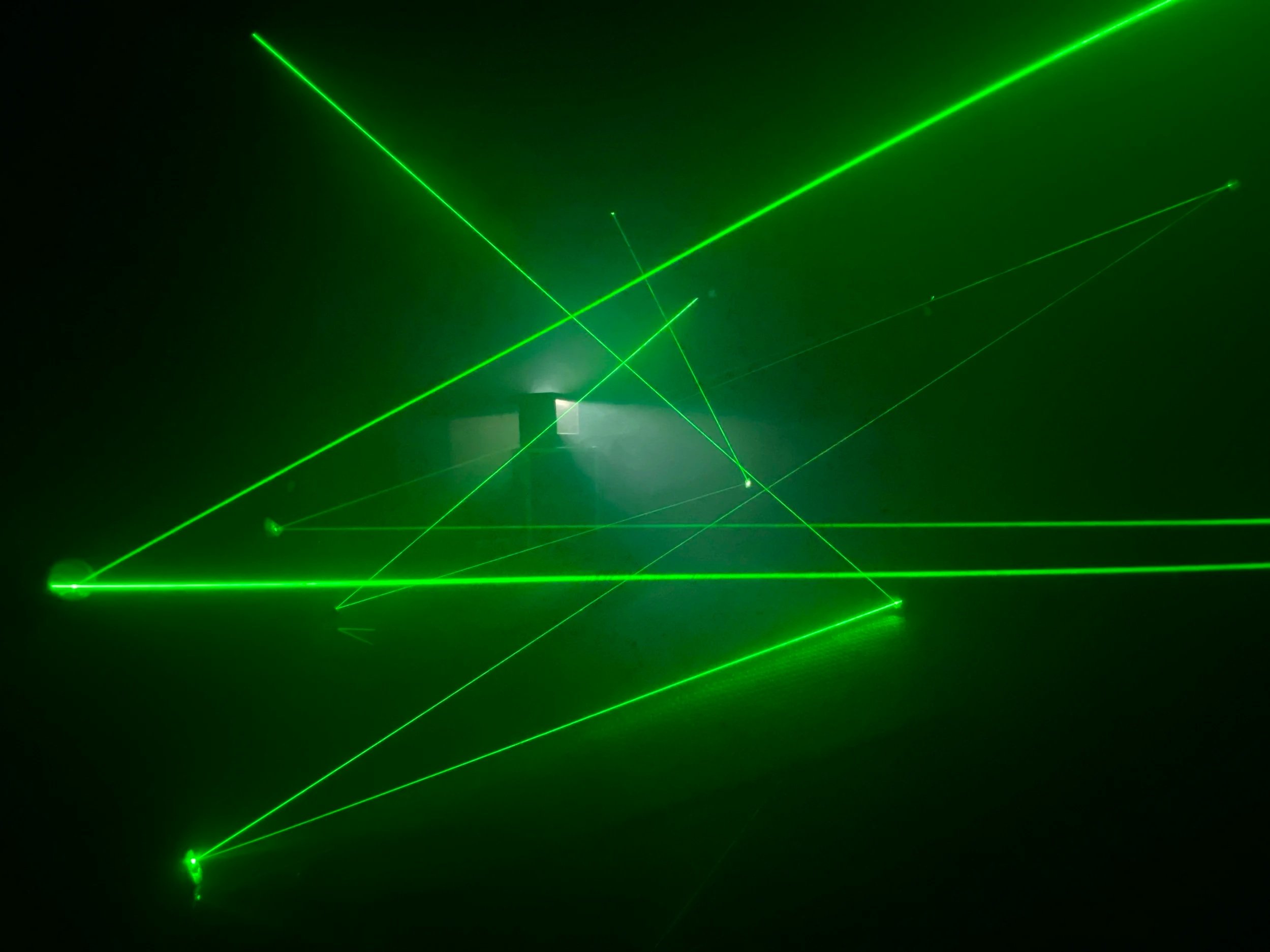 Green laser beams crossing in multiple directions inside the Social Jungle Laser Vault themed room, demonstrating immersive experiential marketing environment