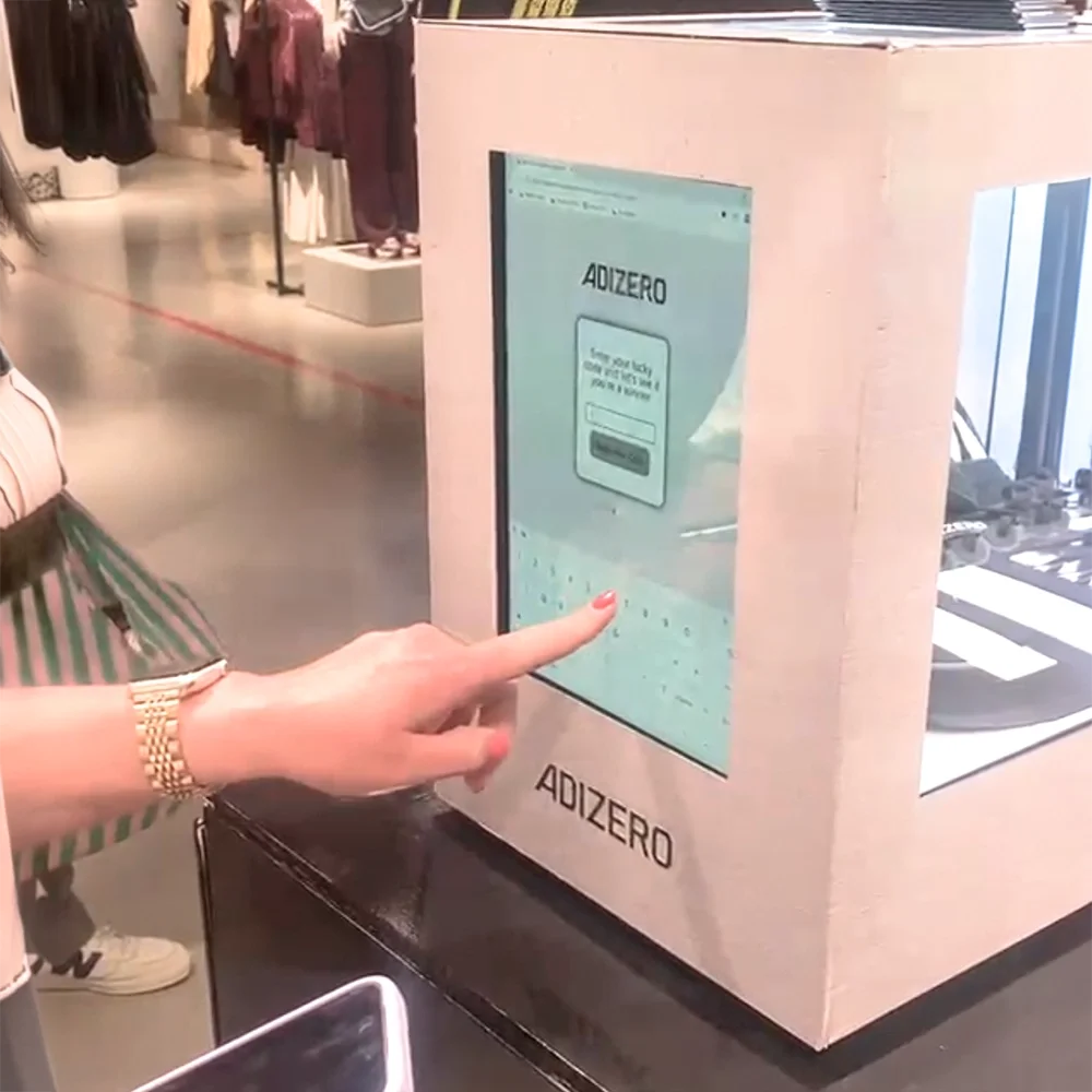 Shopper entering their unique code on the digital keypad of the branded Adidas Lockbox activation.
