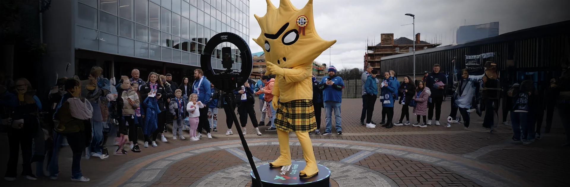Social Jungle 360 video booth hire at the SWPL Sky Sports Cup Final at Tynecastle Stadium — Partick Thistle mascot Kingsley posing on the 360 booth platform in front of a crowd of fans