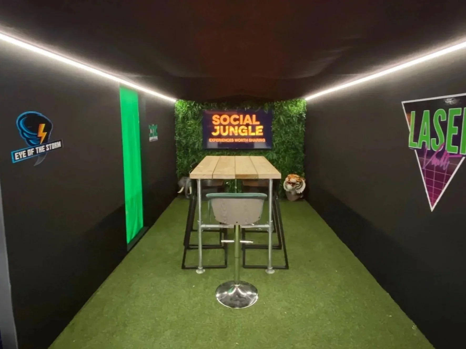 Interior of the Social Jungle Experiential Playground showroom featuring the Eye of the Storm and Laser Vault themed rooms, with branded Social Jungle signage and atmospheric lighting