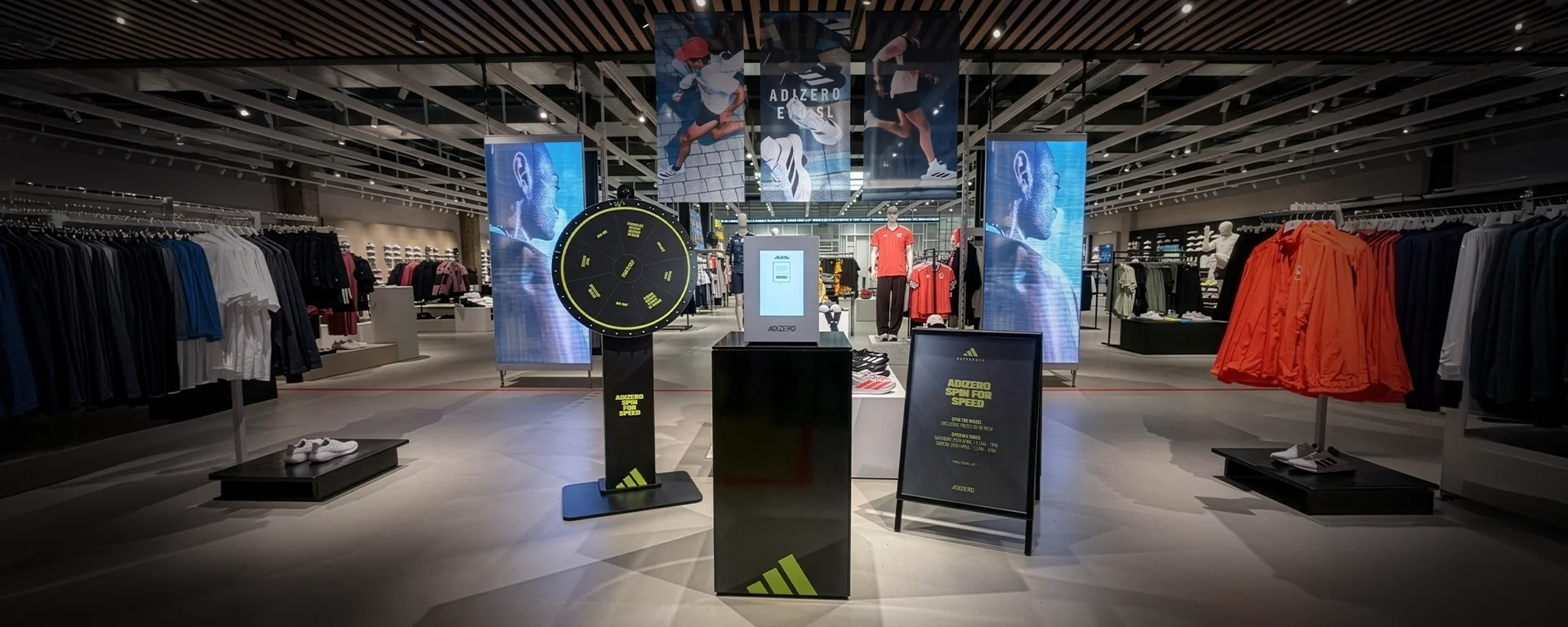 Full ADIZERO Lockbox activation setup at Adidas Battersea Power Station: spin-to-win wheel, Lockbox on a custom plinth, and ADIZERO signage.