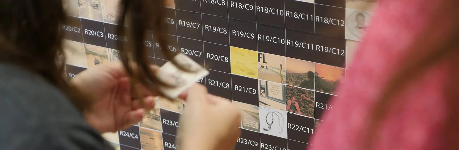 Physical photo mosaic hire UK — guests placing printed photo stickers onto the mosaic grid board at a live event