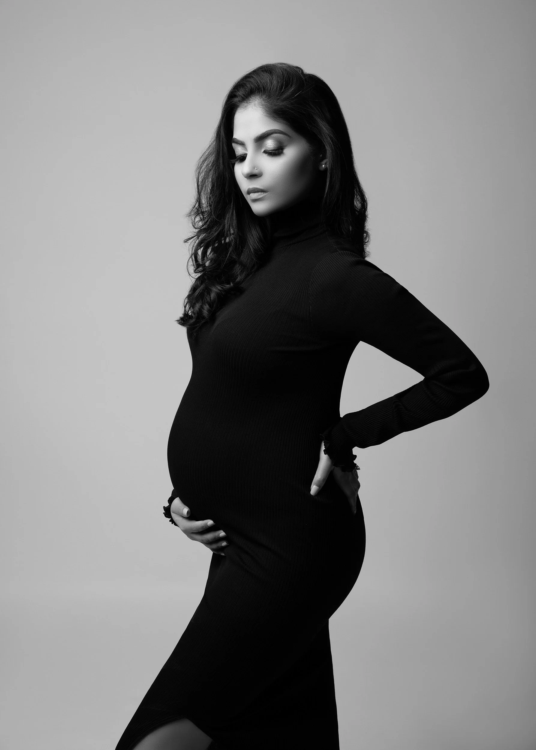 Fashion-inspired black and white editorial maternity portrait of a pregnant woman, photographed in a West London studio.