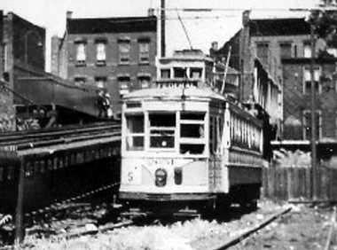 Notes and Photo Provided by Joe Eid The location is the "Pavonia Yard". Behind the camera (south) is Pavonia Avenue. Ahead, up the ramp, is the Newark Avenue station of the Elevated. The JACKSON car is stopped at the northbound station. Only the JACKSON line used this section of the elevated. The OAKLAND cars, which were rush hour only, used it for non-revenue movements to the Greenville Car House. It is evident that since the yard is empty (it could hold, maybe, a dozen cars) it must be rush hour. Why this single FEDERAL CAR IS STORED THERE IS A MYSTERY. It is way off course from its normal run, which was from Exchange Place, Jersey City to Kearny/Harrison. This location is farther north near the Union City/Hoboken border of Jersey City, known as "the Heights." Off to the right of the picture is the old Hudson County Court House. Central Avenue is ahead of the JACKSON car, which is headed for the DL&W Hoboken Terminal, about two miles in front of the car. The tracks, on which the FEDERAL car would run, were over 2 ½ miles to the south. The first day of the FEDERAL line was July 1, 1943 and the last day was July 31, 1945. WW II ended about two weeks later. Al Creamer does not give a date of these pictures but lists it as circa 1944. Al was taking pictures of FEDERAL cars on Montgomery Avenue on 9/16/1944. Also on 9/9/1945, three months after the end of the FEDERAL line, the NRHS ran a fan trip using a 3200 series car on the OAKLAND line but was signed FEDERAL. If the picture is 1944, it isn't a fan trip since the government wouldn't run one during the war. It must have been used on a regular run. Since the only other picture (in Al Mankoff's book Trolley Treasures ) is signed FEDERAL, I am assuming it is a legit picture, not signed FEDERAL by a fan or mistake. By the way the picture in Mankoff's book is on Jackson Avenue, it must be either coming or going to Greenville carhouse on a non-revenue run.