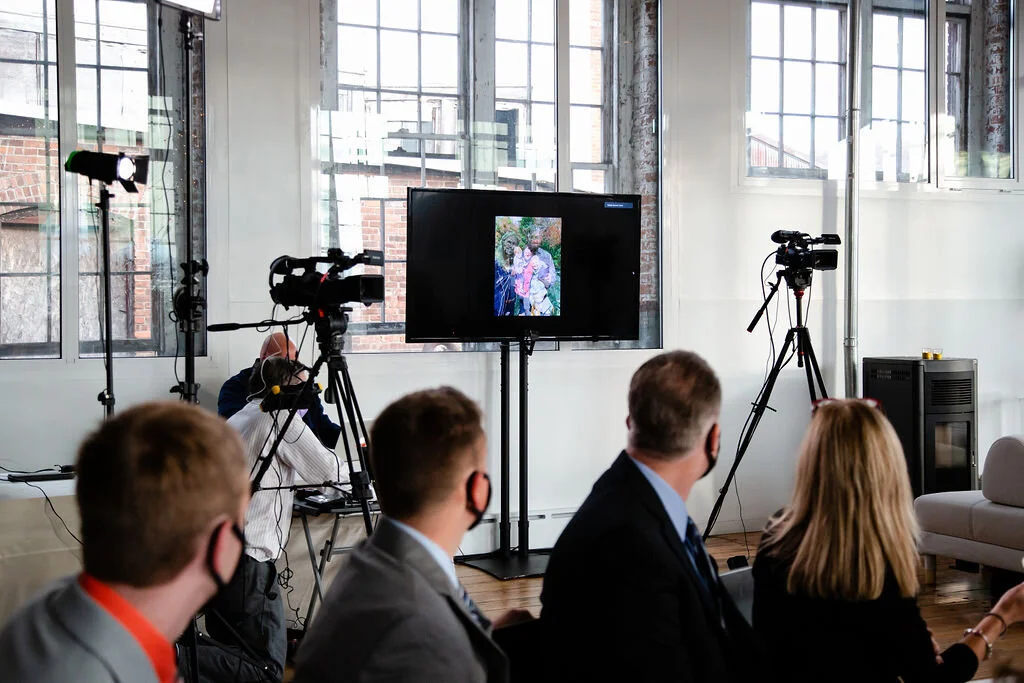 Guests in masks watch slideshow on monitor
