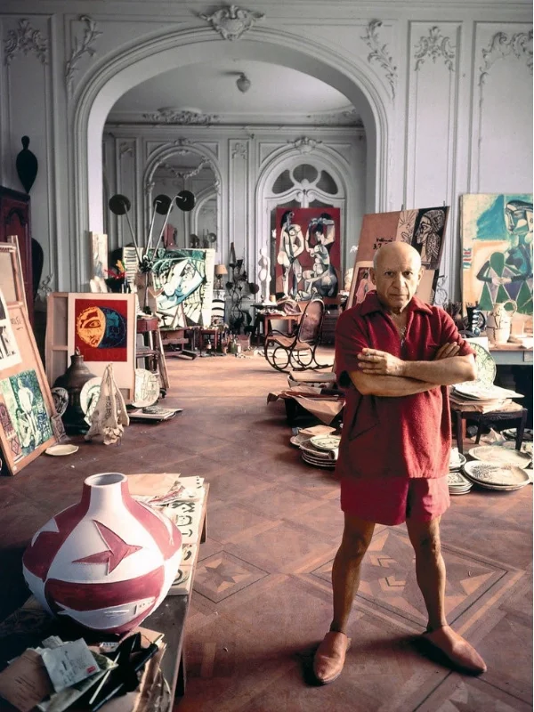 Pablo Picasso photographed in his studio near Cannes, France in 1956. The Thonet rocking chair in the distance appears in many of his paintings. | Source: The New York Times