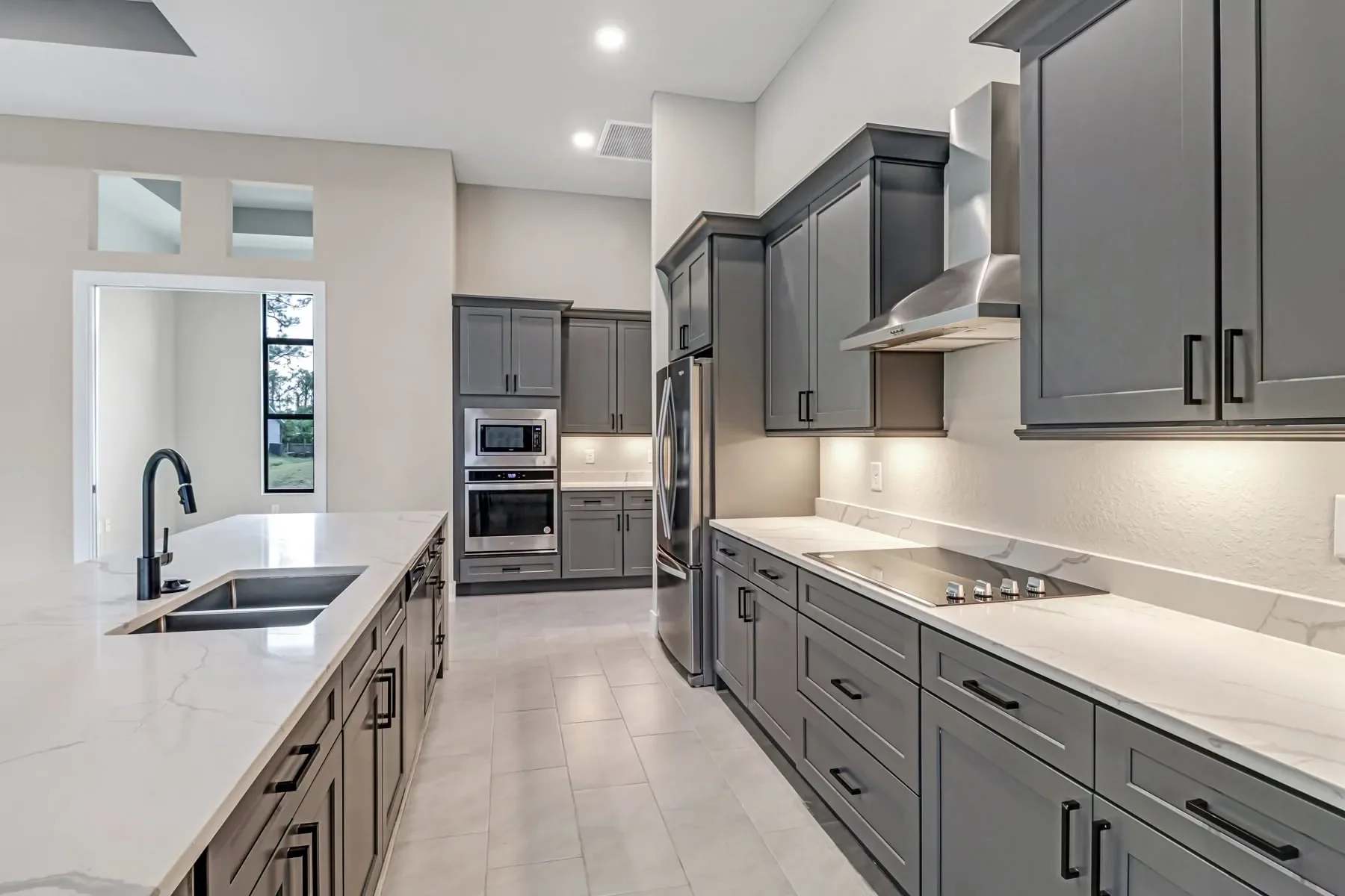 Beautiful kitchen, center island sink, marble counters, stainless steel appliances, custom cabinets, pendant lights, vaulted ceilings, from Sposen Signature Homes of Florida financed by BuildBuyRefi.com