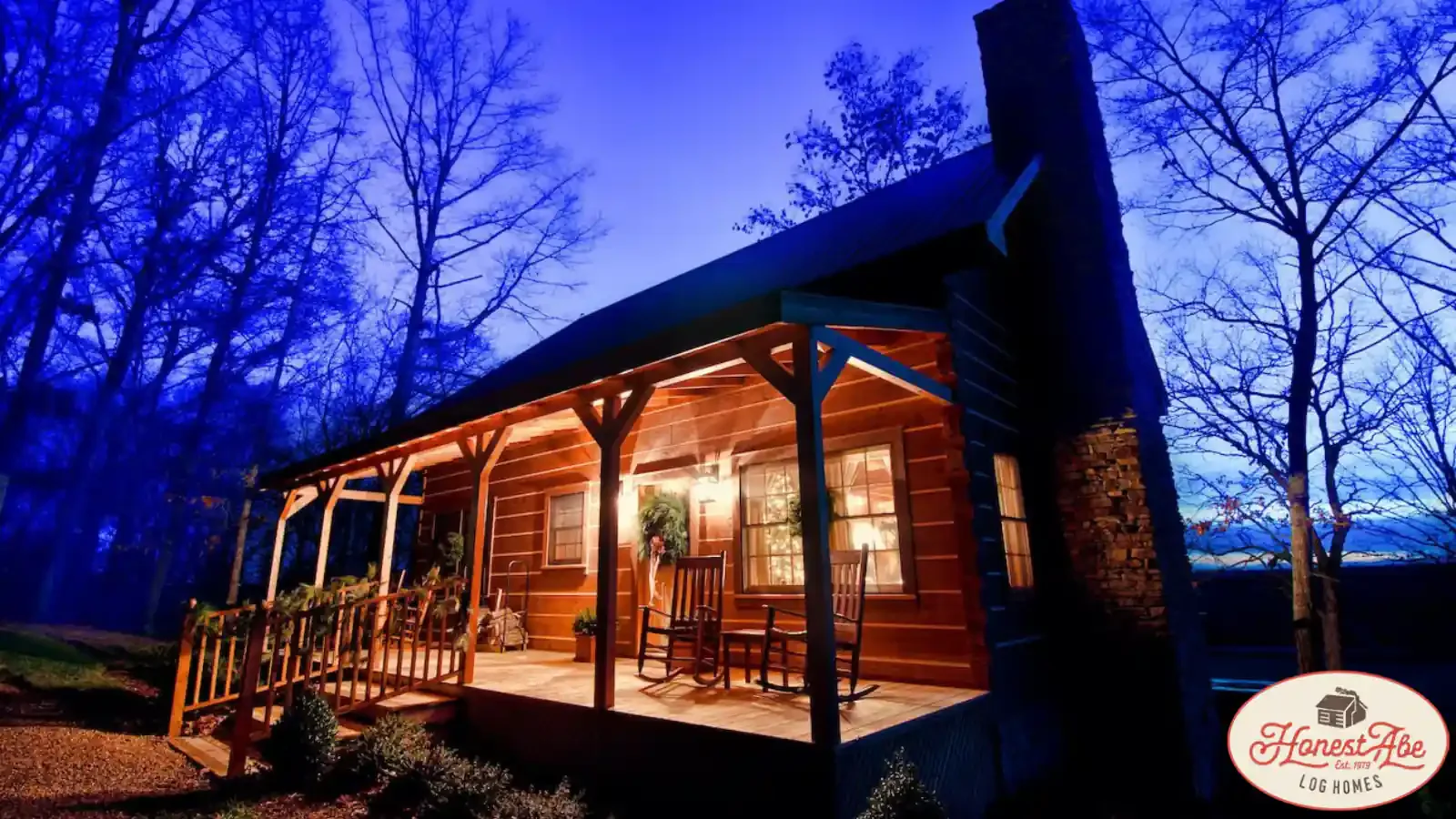ADU Style Small Cabin with Metal Roof, beautiful stone fireplace, covered porch at night-time, custom lighting, great for a 2nd home or vacation property by Honest Abe Log Cabins and BuildBuyRefi.com
