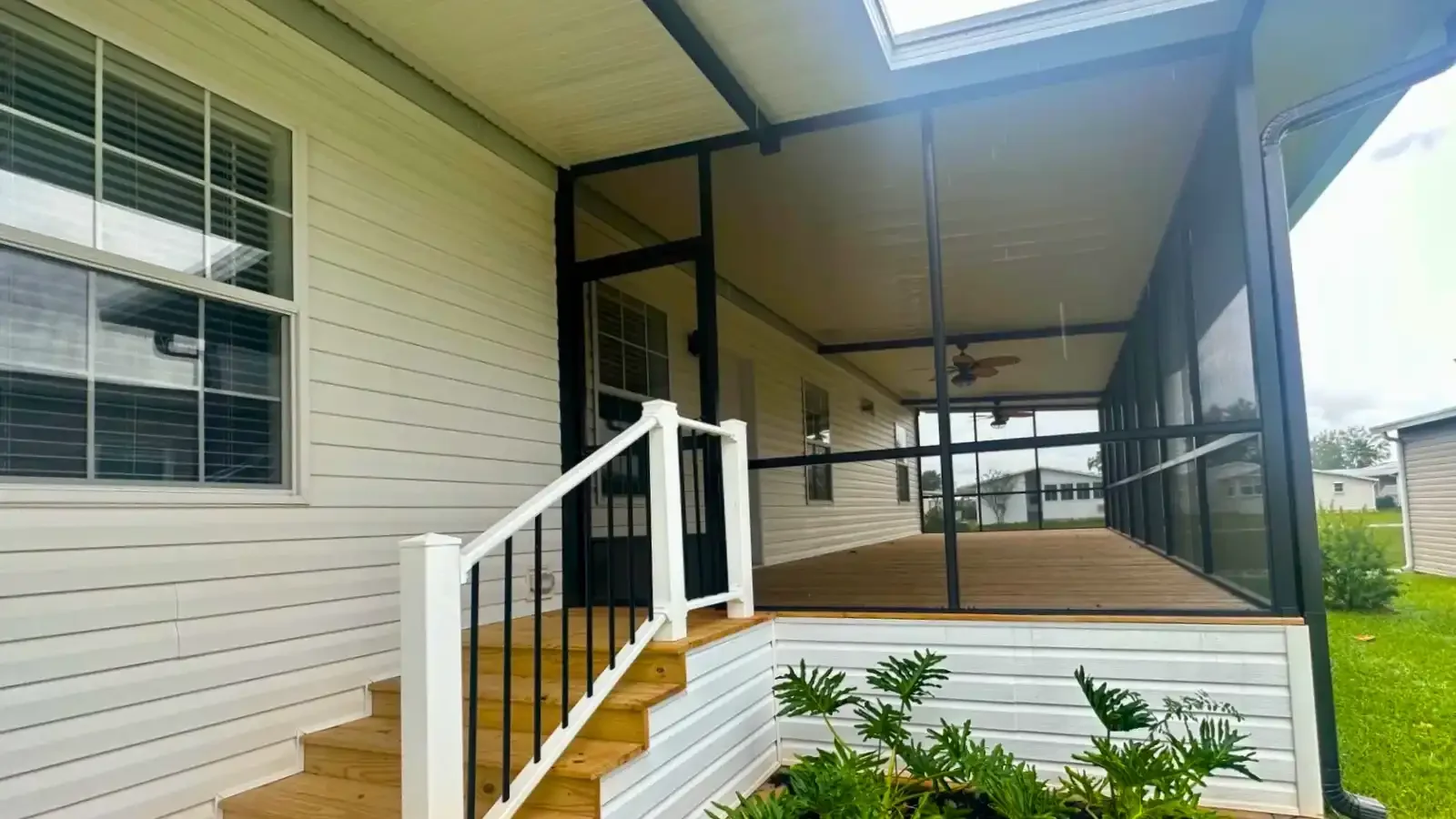 Beautiful screened in florida room with deck, dual ceiling fans, on a custom designed Suncrest Homes of Florida Manufactured property financed by BuildBuyRefi Home Loans.