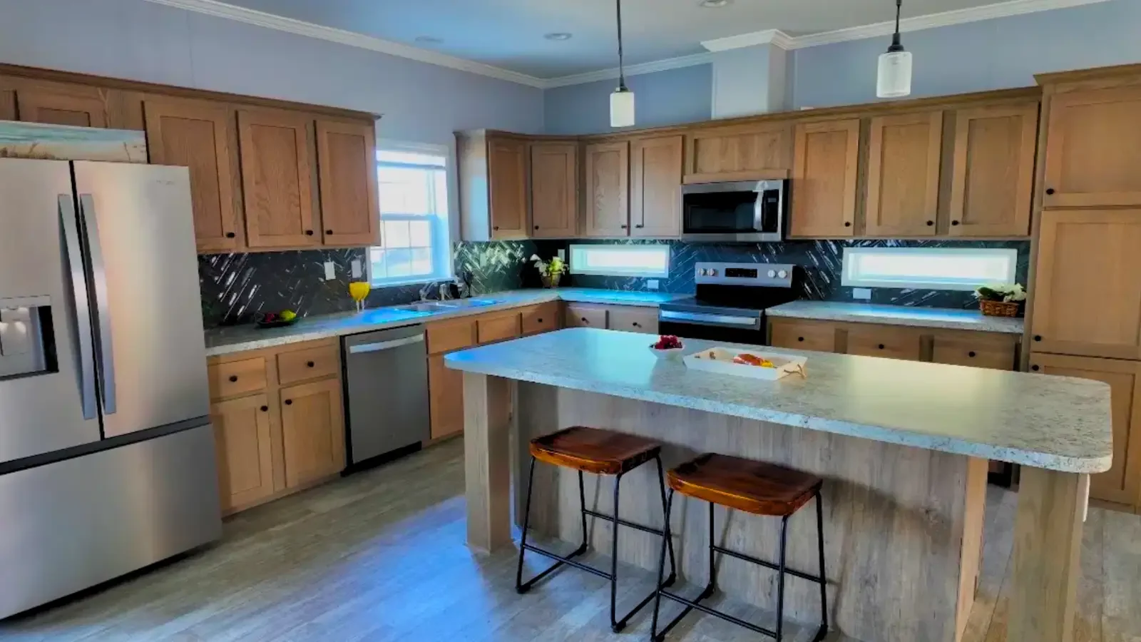 Beautiful kitchen, center island, stainless steel appliances, maple cabinets, pendant lights from Suncrest Homes of Florida financed by BuildBuyRefi.com