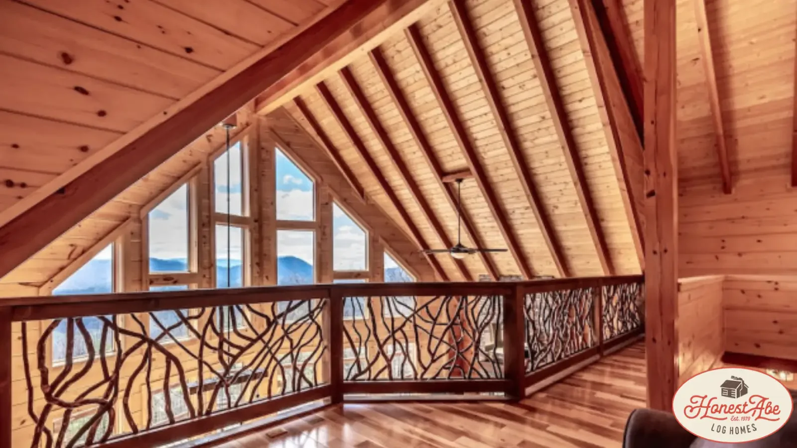 Loft View of the 2 Story Great Room and Custom Windows, Hardwood Flooring, Dramatic Windows framing out the mountains in a Custom Log Home by Honest Abe Log Homes, financed by BuildBuyRefi Home Loans.